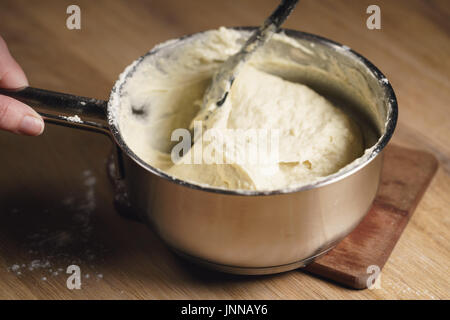weibliche Hände mischen klebrigen Teig Stockfoto