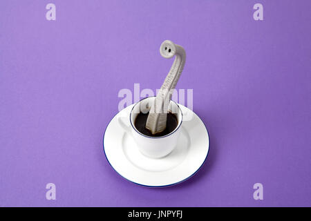 Ein Elefantenrüssel entstehende eine kleine Tasse Kaffee, als ob er versteckt hielten. Minimalistisches Design für lustige und skurrile Still Life Fotografie Stockfoto