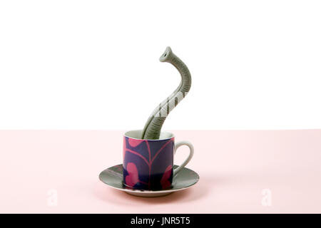 Ein Elefantenrüssel entstehende eine kleine Tasse Kaffee, als ob er versteckt hielten. Minimalistisches Design für lustige und skurrile Still Life Fotografie Stockfoto