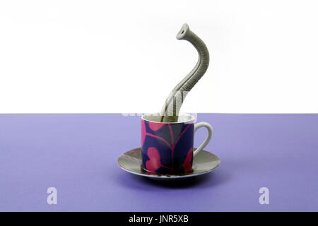 Ein Elefantenrüssel entstehende eine kleine Tasse Kaffee, als ob er versteckt hielten. Minimalistisches Design für lustige und skurrile Still Life Fotografie Stockfoto