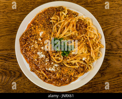 Italienische Spaghetti Bolognese Essen vor einem dunklen Eiche Holz Hintergrund Stockfoto