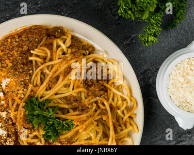 Italienische Spaghetti Bolognese Essen gegen einen schwarzen Schiefer Fliesen Stockfoto