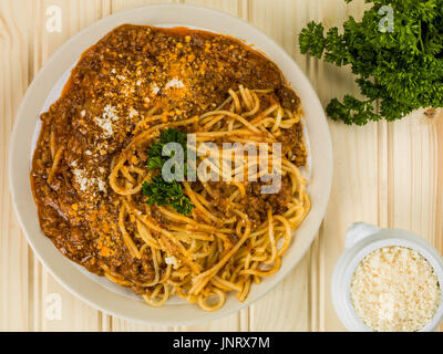 Italienische Spaghetti Bolognese Essen gegen eine leichte Kiefer-Holz-Hintergrund Stockfoto