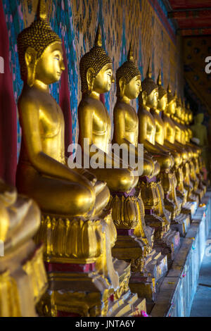 Reihe von Golden sitzender Buddha Statuen am Wat Arun (Tempel der Morgenröte) in Bangkok, Thailand Stockfoto