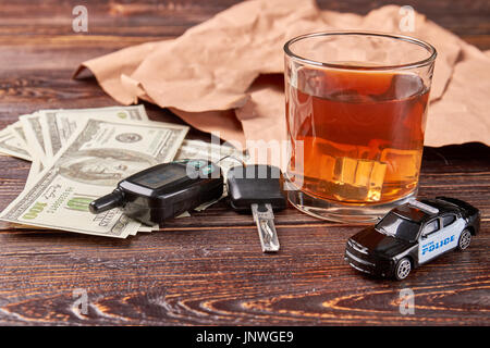 Dollar, Schlüssel, Whiskey, Polizeiauto. Stockfoto