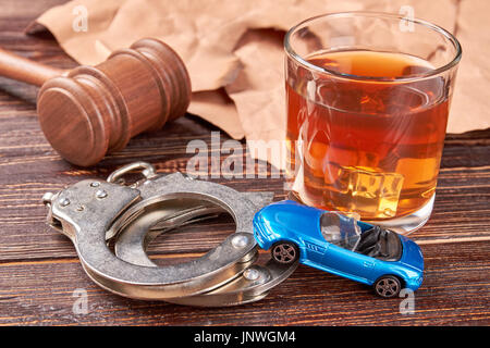 Hammer, Handschellen, Auto, Whiskey, Papier. Stockfoto