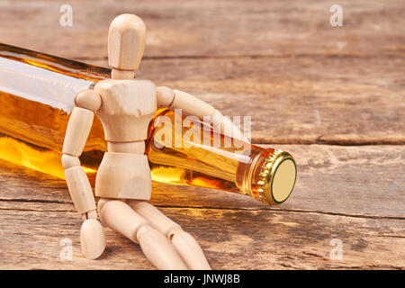 Menschlichen Holzpuppe umarmt Flasche. Stockfoto