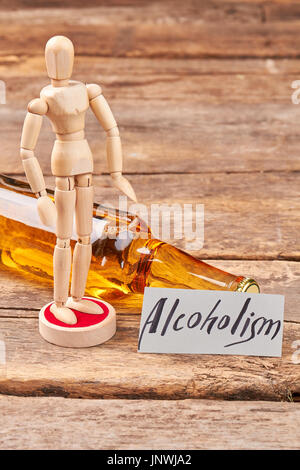 Eine Flasche Alkohol, menschliche Holzpuppe. Stockfoto