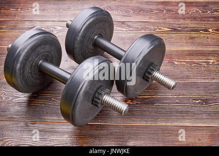 Trainings-Hanteln auf Holzboden. Stockfoto