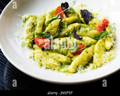 Gnocchi mit Pesto und Parmesan. Vorbereiten von Ofenkartoffeln mit dem Zusatz von Eigelb und Mehl harte Sorten. In Pesto-Sauce mit Zucchin serviert Stockfoto