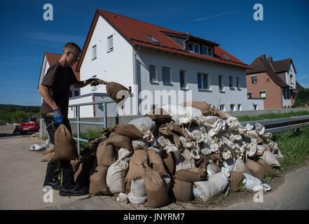 Hildesheim, Deutschland. 31. Juli 2017. Noah Griebner stapelt Sandsäcke vor einem Wohnhaus in Iztum Viertel in Hildesheim, Deutschland, 31. Juli 2017. Kontinuierliche Niederschläge führen zu Überschwemmungen in einigen Städten des Landes Niedersachsen. Foto: Silas Stein/Dpa/Alamy Live News Stockfoto