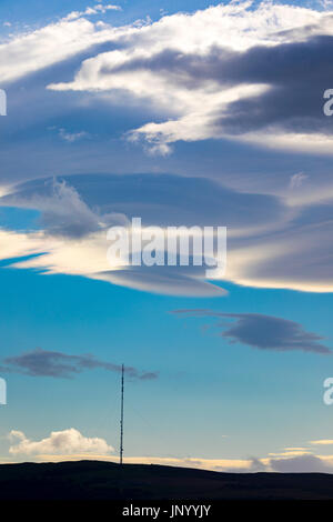 Seltsame Wolken bekannt als linsenförmige Wolken erscheinen über den Moel-y-Parc Mast auf den Hügeln Clwydian Range, Wales Stockfoto