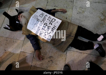 Israel, Jerusalem 31. Juli. Orthodoxer jüdischer Mann, der Jutebeutel trägt, um Trauer auf dem Tisha B’Av-fest an der Westmauer in Jerusalem am 31. Juli 2017 zu bezeichnen. Tisha B’Av ist ein jährlicher Fastentag im Judentum, der an die Zerstörung des ersten und zweiten Tempels in Jerusalem erinnert, die etwa 656 Jahre auseinander, aber am selben Tag stattfand. Dementsprechend wurde der Tag als der traurigste Tag in der jüdischen Geschichte bezeichnet. Stockfoto