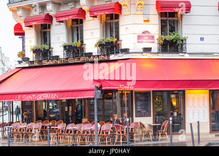 Paris, Frankreich - 2. März 2016: Le Saint Germain Restaurant Café mit roten Markisen, leuchtet am frühen Morgen mit noch auf. Stockfoto