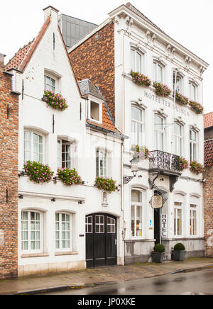 Brügge, Belgien – 31. Oktober 2010: Hotel Ter Duinen auf Langerei mit rosa Geranien in Balkonkästen an einem regnerischen Tag, Brügge, Belgien. Stockfoto