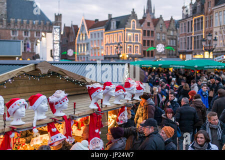 Brügge, Belgien - 15. Dezember 2013: Menschenmassen auf dem Weihnachtsmarkt auf dem Hauptplatz in Brügge, Belgien. Stockfoto