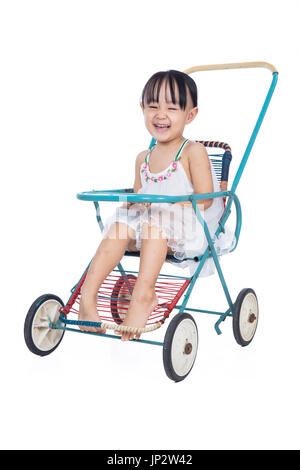 Asiatische chinesische Mädchen sitzen in einem Retro-Kinderwagen in isolierten weißen Hintergrund Stockfoto