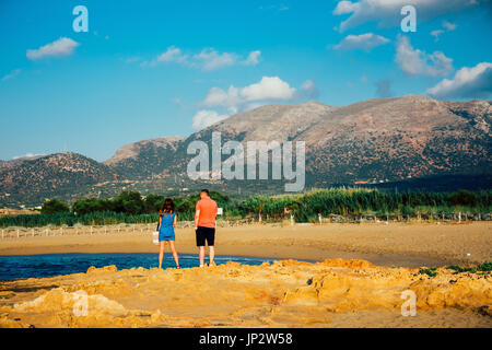 Malia, Kreta, Griechenland, 12. Juni 2017: Ein paar junge Menschen, eine Frau und ein Mann, bewundern die Aussicht auf die Berge während des Sonnenuntergangs in der Nähe von Malia, Stockfoto