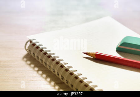 Roten Bleistift und Radiergummi auf leere Spiral-Notizbuch auf Schreibtisch. Platz für Ihren text Stockfoto