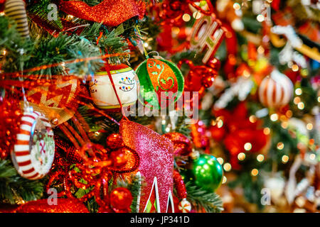 Christbaumschmuck und Lampen hängen an einem traditionellen Weihnachtsbaum während der Weihnachtszeit. Stockfoto