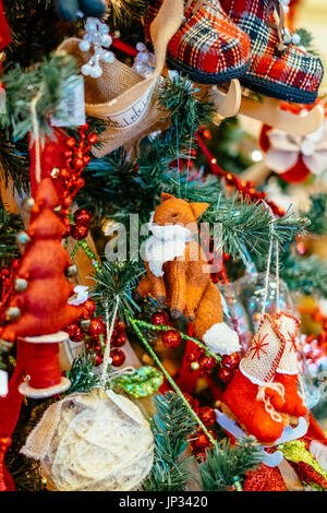 Christbaumschmuck und Lampen hängen an einem traditionellen Weihnachtsbaum während der Weihnachtszeit. Stockfoto