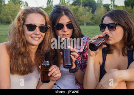 Weibliche Freunde feiern den Urlaub eine gute Zeit Bier trinken in einem Park. Stockfoto