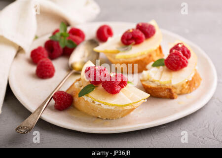 Offenen konfrontiert Sandwiches mit Käse, frischen Birnen und Himbeeren Stockfoto