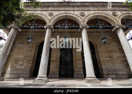 Weitwinkel der Vorderseite einer Kirche mit Säulen und schwarze Lampen (Santander, Kantabrien, Spanien). Stockfoto
