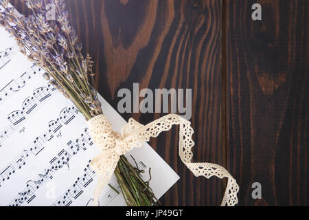 Lavendel und Papier Musik Hinweise zur alten hölzernen Hintergrund im Vintage-Stil, Ansicht von oben. Stockfoto