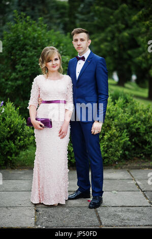 Gut aussehendes Paar feiern ihren Abschluss an der Universität, posiert außerhalb in schöne Kleidung. Stockfoto