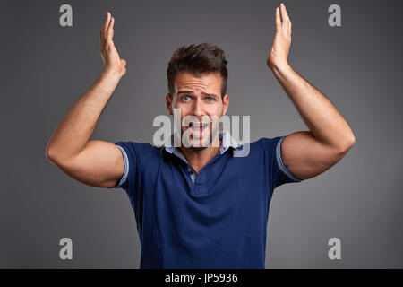 Ein hübscher junger Mann fühlen, schockiert und schreien Stockfoto