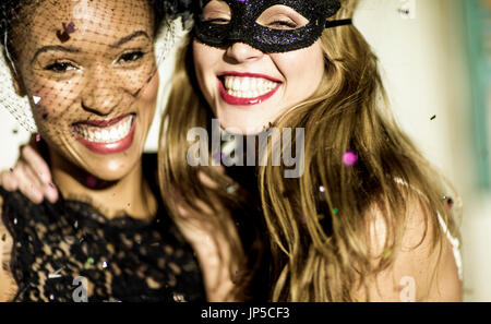 Eine junge Frau mit langen blonden Haaren auf einer Glitzer-Party mit fallenden Konfetti. Stockfoto