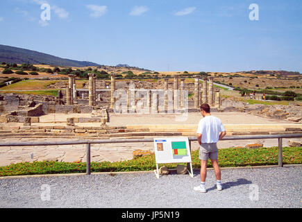 Mann liest das Hinweisschild. Römische Ruinen Baelo Claudia, Tarifa, Cadiz Provinz, Andalusien, Spanien. Stockfoto