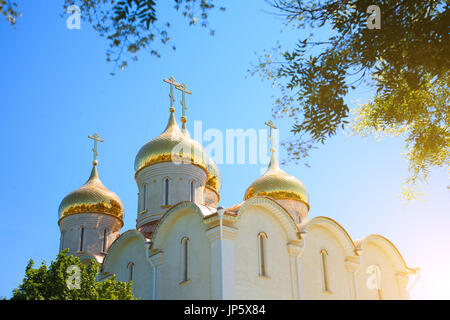 Goldene Kuppeln der orthodoxen Kirche gegen den blauen Himmel an einem sonnigen Tag. Stockfoto