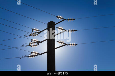 Hintergrundbeleuchtung Silhouette der Stromleitung gegen blauen Himmel. Alternativen Energien Konzept Stockfoto