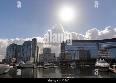 Riesige Sonne auf Docklands, Melbourne, Victoria, Australien. Gebäude am Wasser und Marina, Wasser und Glas Sekt in der Sonne. Stockfoto