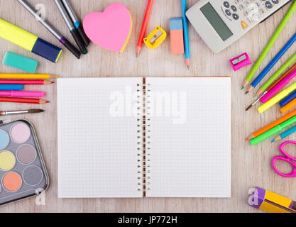 Ansicht von oben offene leere Arbeitsmappe auf hölzernen Schreibtisch mit Schulmaterial herum. Bildung und Kreativität-Konzept Stockfoto