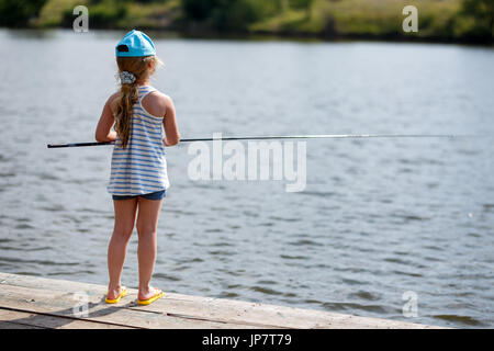 Mädchen aus einem Dock auf einem See oder Teich angeln. Stockfoto