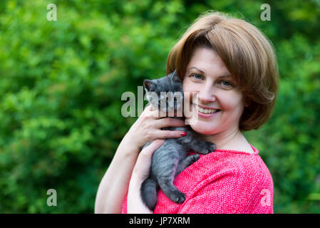 Frau umarmt eine blaue Kitten Scottish Meerenge in der Natur Stockfoto