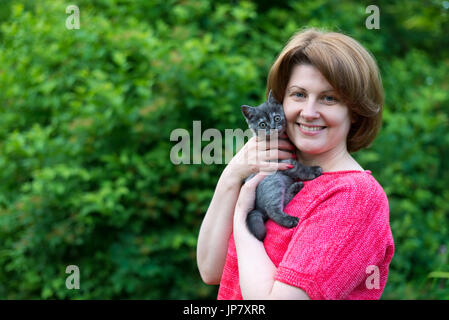 Frau umarmt eine blaue Kitten Scottish Meerenge in der Natur Stockfoto