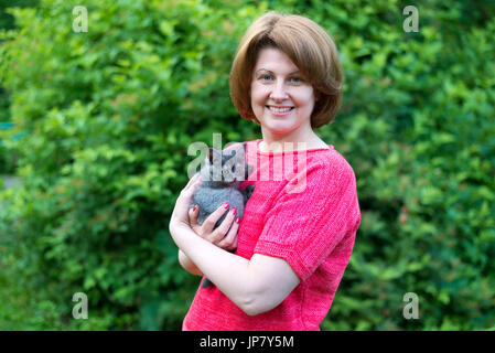 Frau umarmt eine blaue Kitten Scottish Meerenge in der Natur Stockfoto