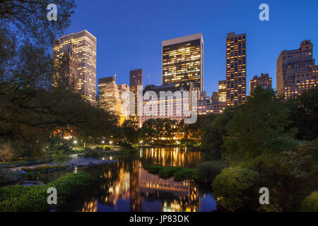 Central Park in der Dämmerung mit Reflexionen von Gebäuden in Midtown Manhattan, New York City USA Stockfoto