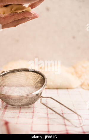 Sieb, Hände und Knödel: hausgemachte Dim Sum Vorbereitung zu Hause. Stockfoto