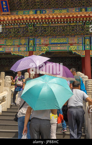 Touristen halten bunte Schatten Sonnenschirme nähert sich die Halle der höchsten Harmonie in der verbotenen Stadt, Peking, China Stockfoto