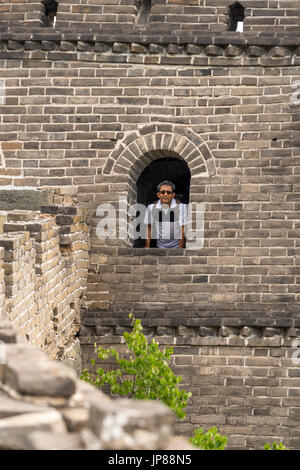 Indische Touristen in seinem Anfang der 50er Jahre mit Blick vom gewölbtes Fenster an der chinesischen Mauer Stockfoto