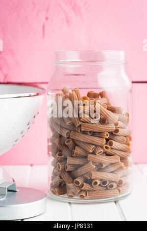 Getrocknete Rigatoni Nudeln in Glas.  Dunkle Grieß Nudeln. Teigwaren. Stockfoto