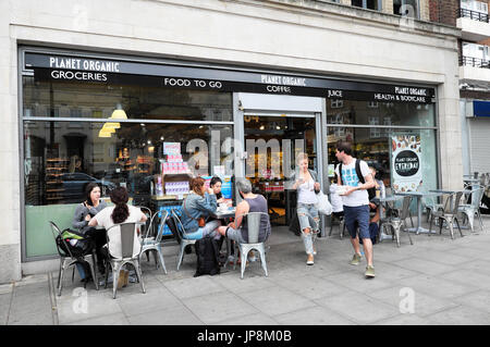 Leute sitzen an Tischen im freien Planeten Supermarkt Naturkostladen in Essex Road in London N1 UK KATHY DEWITT Essen trinken Stockfoto