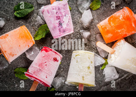 Gesunden Sommer Desserts. Eis Eis am Stiel. Gefrorene tropische Säfte, Smoothies Blaubeeren. Johannisbeere, Orange, Mango, Kiwi, Banane, Kokos, Himbeere Stockfoto