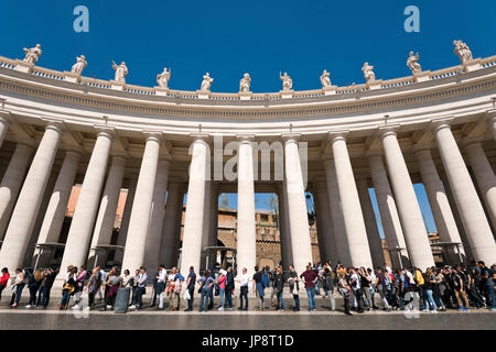 Horizontale Ansicht von Touristen Warteschlangen vor den Kolonnaden rings um Platz St. Peter im Vatikan in Rom. Stockfoto