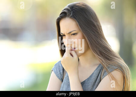 Nervöse Mädchen beißen Nägel draußen auf der Straße Stockfoto